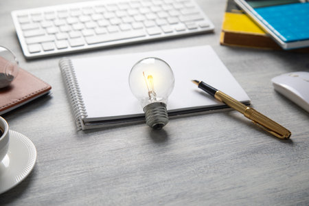 Light bulb with a business objects on the table.の写真素材