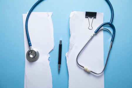 Stethoscope and torn documents on the blue background.の写真素材