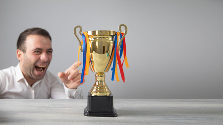 Man holding a winner golden trophy cup.