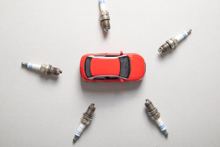 Car spark plugs and toy car on the gray background.の写真素材