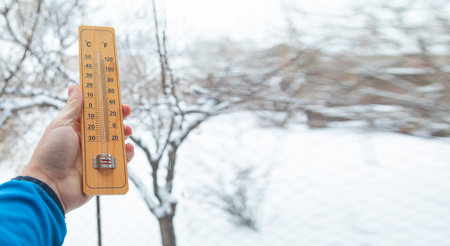 Thermometer at winter snow background. Bad weatherの写真素材