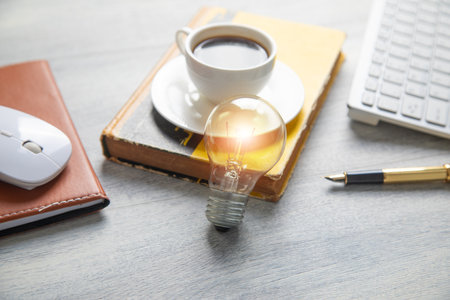 Light bulb with a business objects on the table.の写真素材