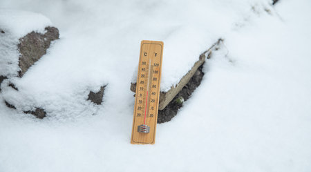 Thermometer at winter snow background. Bad weatherの写真素材