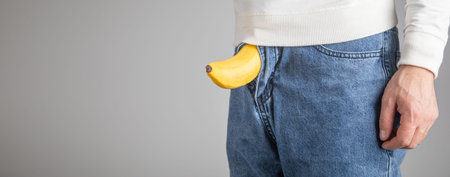 Man showing banana over his jeans.の写真素材