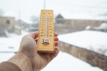 Male hand showing thermometer at winter.の写真素材