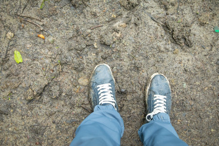 Selfie of sneakers on the ground, closeup of legs.