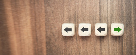 Wooden blocks with arrows pointing in different directions on a wooden background
