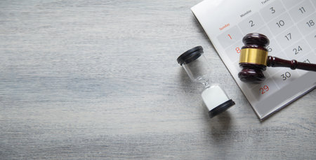 Hourglass and calendar on wooden background with copy space. Law concept