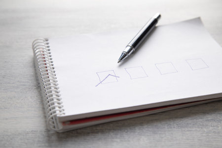 Notebook and pen on wooden table, closeup. Business concept