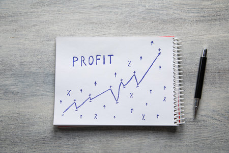 Profit text and growing arrows on notepad. Business concept