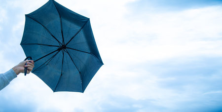 Caucasian man showing umbrella in outdoors.