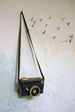 very old toy camera hanging on nail.の写真素材