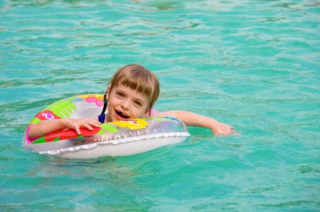 Cute little girl Happily playing in the swimming pool .