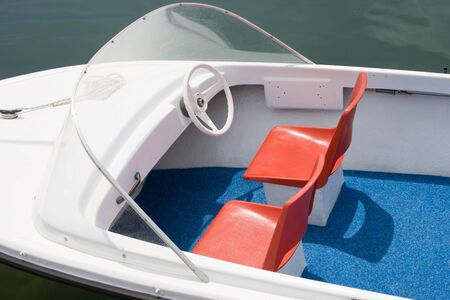 Very minimal -styled white motorboat with red seats and blue floor.の写真素材
