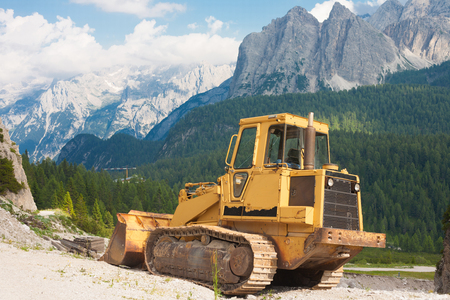 Road contsruction with a bulldozer in the front in the Dolomites, Italyの写真素材