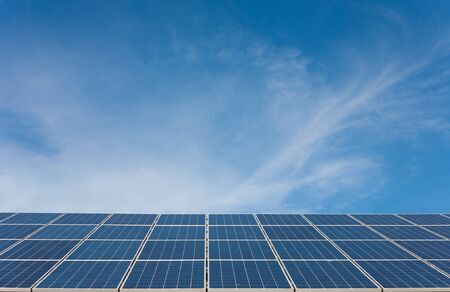 Sun energy - Solar panels on a house top and cloudy blue sky