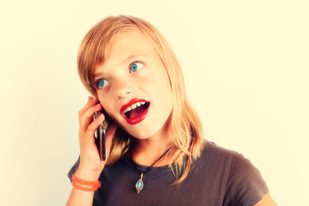 Little girl telephoning using smartphone. Photo with nostalgic warm contrast effect.の写真素材