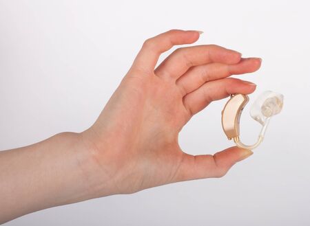 Hand showing a hearing aid with ear mould