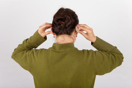 Woman inserting her hearing aids