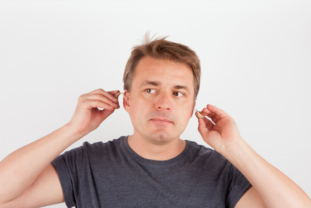 Man putting hearing aids into earsの写真素材