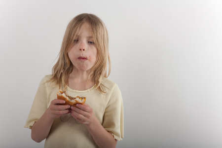 Adorable young girl presenting unhealthy eating with a cheeseburgerの写真素材