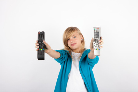 Adorable girl showing TV remote controls.の写真素材