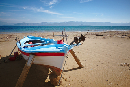 Fisherboat before tourist season at Kavos beach in Corfu, Greeceの写真素材