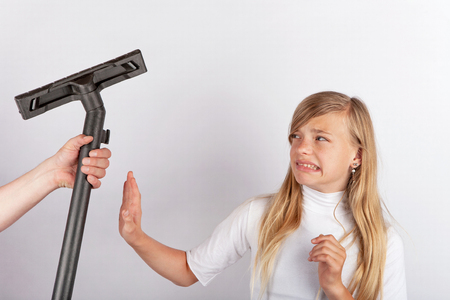 Hand holding a vacuum tube but the girl refusing housework.の写真素材