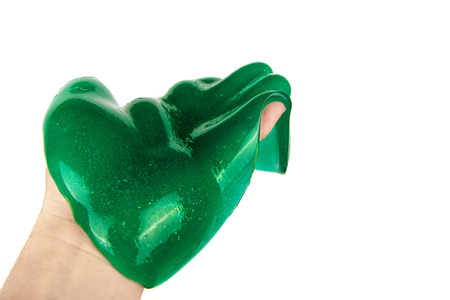 Liquid green slime child toy flowing on hand. Isolated on white background.