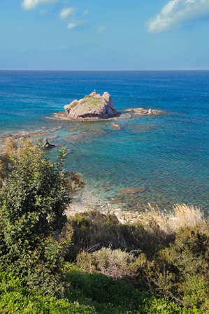 Small island with the cross in top. Blue deep sea around.の写真素材