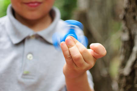 Boy playing with a Tri Fidget Hand Spinnerの写真素材