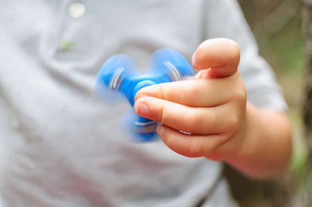 Boy playing with a Tri Fidget Hand Spinnerの写真素材