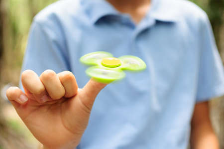 Boy playing with a Tri Fidget Hand Spinnerの写真素材