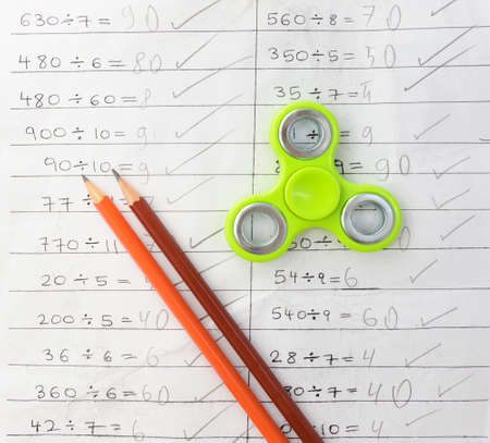 Fidget spinner  influences dor education at school. Notebook background