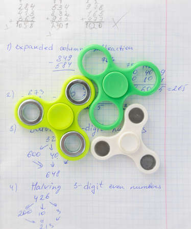 Fidget spinner  influences dor education at school. Notebook background