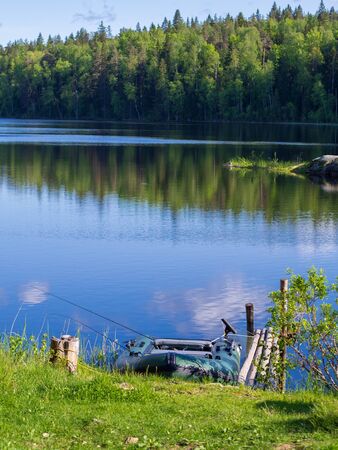 Inflatable boat with fishing rods on the lakeの写真素材