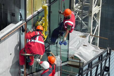 Construction of a glass wall, crane and industrial climbers. Russia, St. Petersburg, Stockman 06/23/2010の写真素材