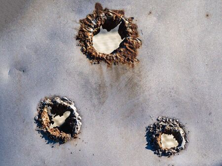 War actions aftermath, a bullet hole in the metal sheeの写真素材