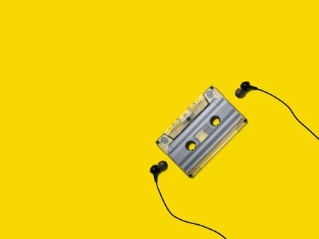 Headphones and old audio cassette on yellow background/の写真素材