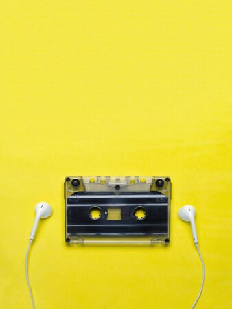 Headphones and old audio cassette on yellow background/の写真素材