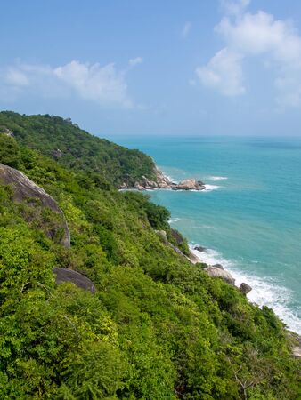 Rocky rock over beautiful clear sea and island, view from Kho Phangan, Thailand.の写真素材