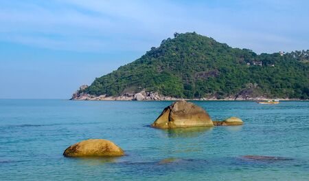 Rocky rock over beautiful clear sea and island, view from Kho Phangan, Thailand.の写真素材