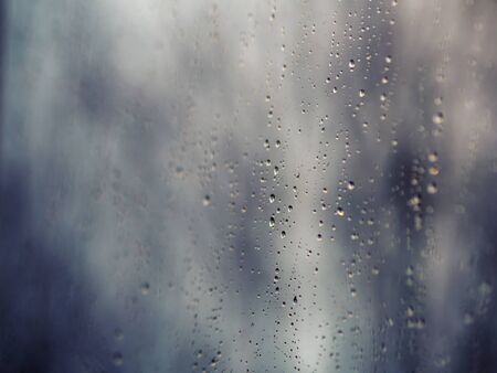 

Raindrops on the surface of window glass with a blurred background.の写真素材