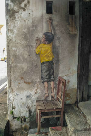 PENANG, MALAYSIA-2018-01-05: Street Mural entitled 'Reaching Up' painted by Ernest Zacharevic in Penang on July 6, 2013. It was painted in conjunction with the 2012 George Town Festivalのeditorial素材