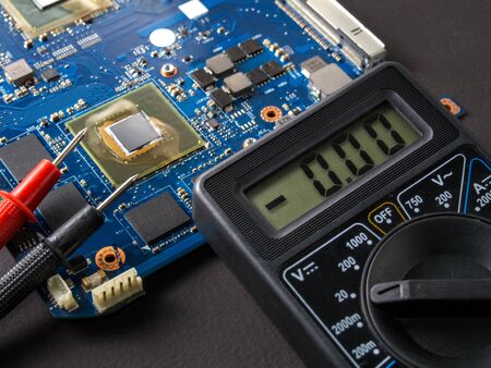 Multimeter test, electronic board of digital device with components. Troubleshoot electronic device. Computer and mobile device repair conceptの写真素材