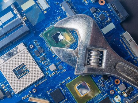 Computer repair concept, wrench on motherboard close upの写真素材