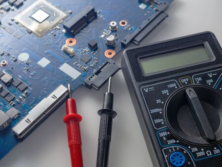 Multimeter test, electronic board of digital device with components. Troubleshoot electronic device. Computer and mobile device repair conceptの写真素材