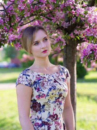 Young beautiful blonde woman in blooming garden. Bride.の写真素材