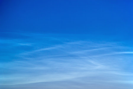 White Spindrift clouds on blue skyの写真素材