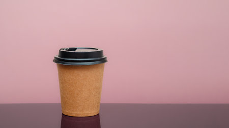 coffee to go in a disposable cup on the table and pink background. space for textの写真素材